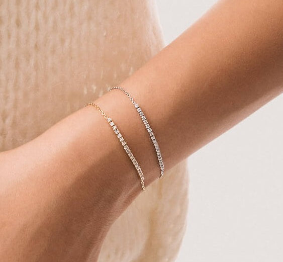 Anate fine jewelry — Aurea diamond smile bracelets in solid yellow and white gold, stacked on model's wrist testimonial image
