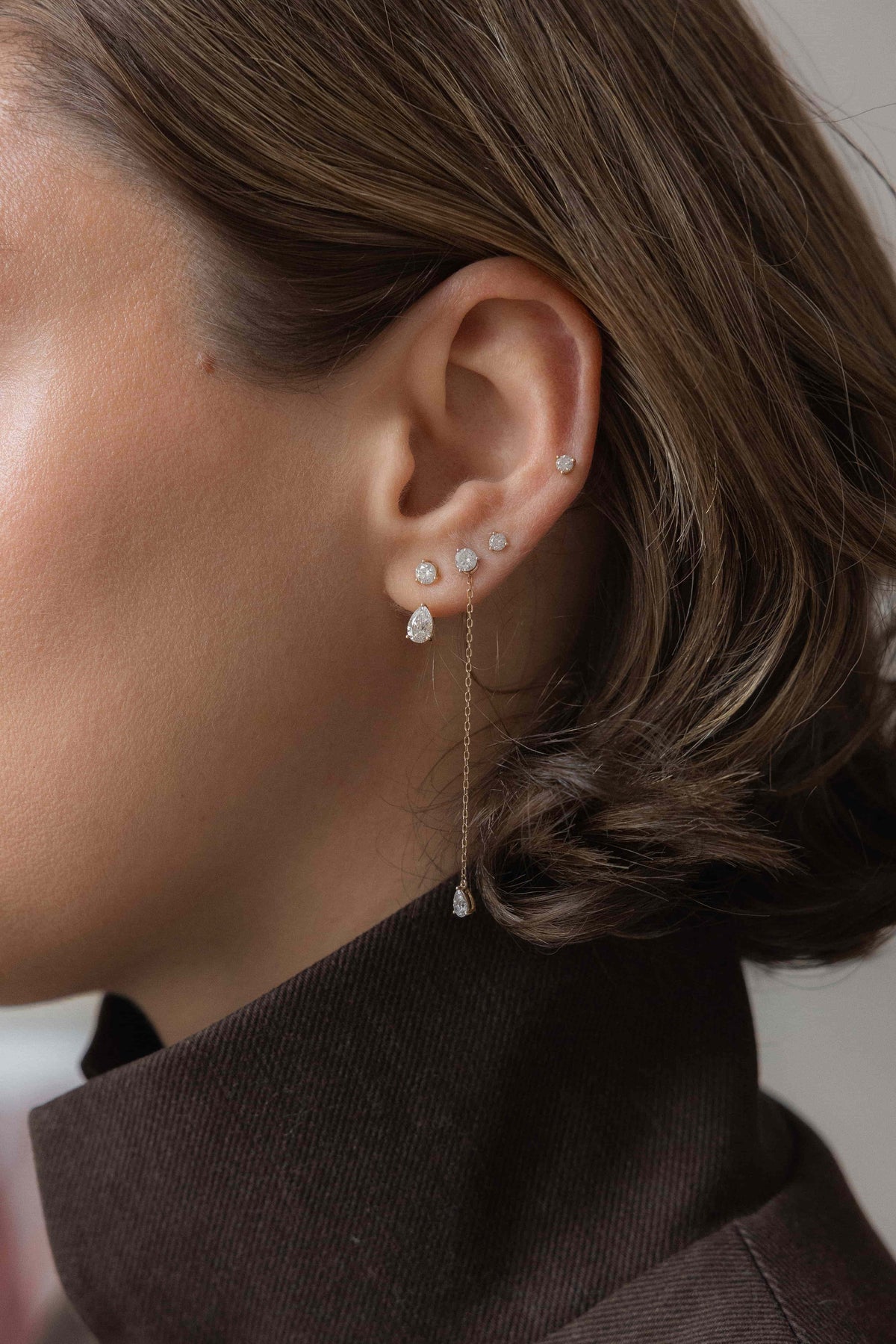 Close-up of a model wearing Anate diamond ear stack with stud and drop earrings, showcasing affordable fine jewelry.