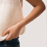 Model wearing the Aurea diamond smile bracelet in solid white gold by Anate, worn on wrist