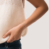 Model wearing the Aurea diamond smile bracelet in solid yellow gold by Anate, worn on wrist