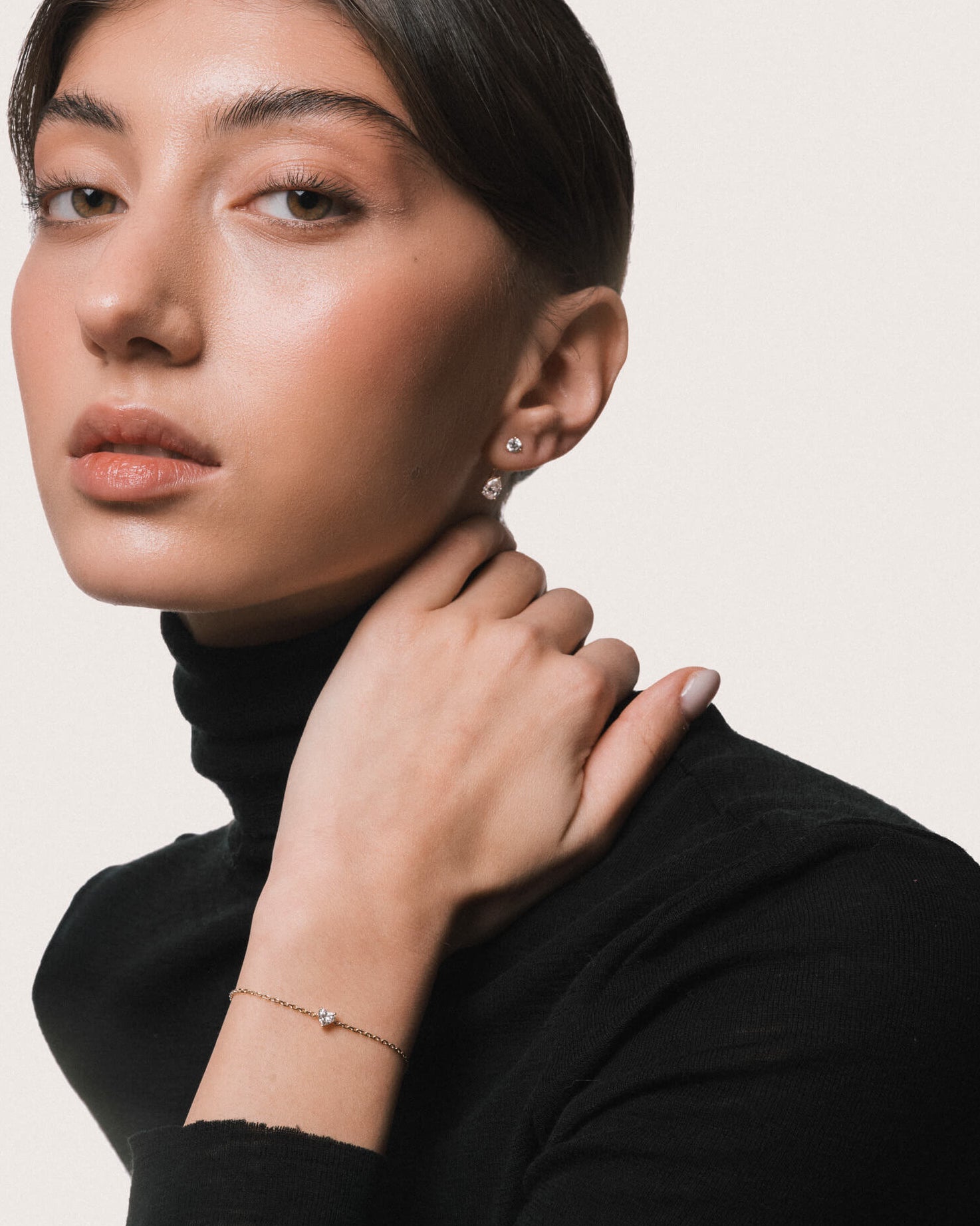 Model wearing the Mara heart diamond bracelet in solid yellow gold by Anate, worn on model, portrait shot