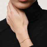 Model wearing the Mara heart diamond bracelet in solid yellow gold by Anate, worn on model, portrait shot
