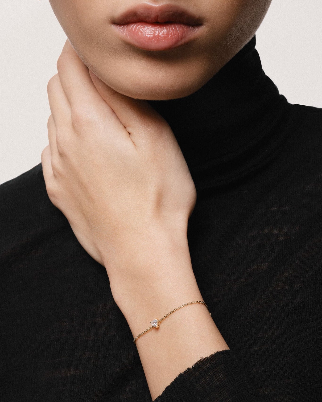 Model wearing the Mara heart diamond bracelet in solid yellow gold by Anate, worn on model, portrait shot