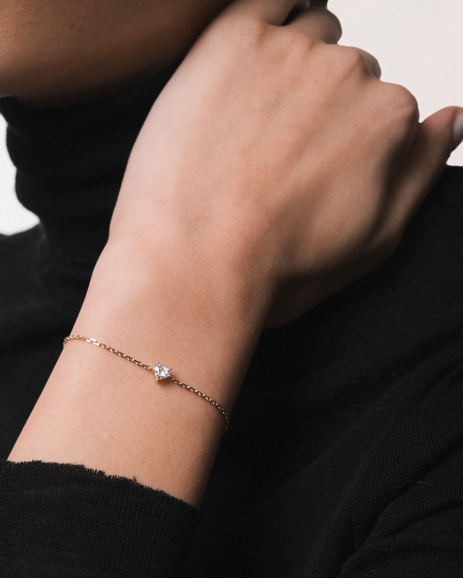 Model wearing the Mara heart diamond bracelet in solid yellow gold by Anate, worn on wrist