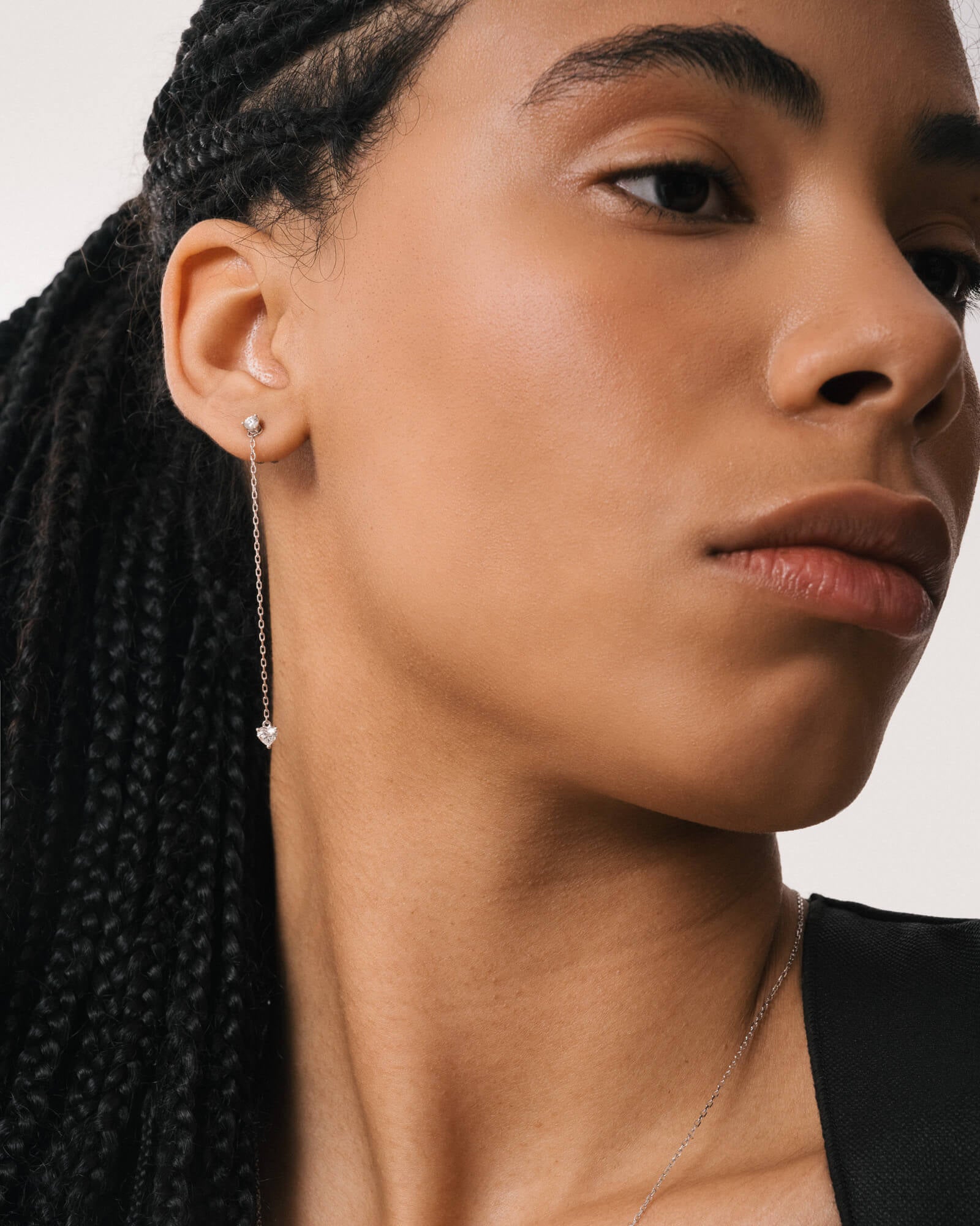 Model wearing the Raya heart diamond drop earrings in solid white gold by Anate, worn on ear