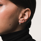 Model wearing the Nia heart diamond ear jacket earrings in solid white gold by Anate, worn on ear variant--0.25ct