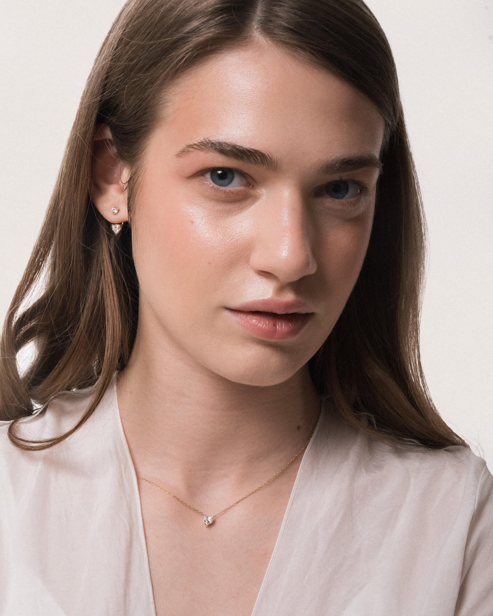 Model wearing the Lumi heart diamond pendant in solid yellow gold by Anate, worn on neck