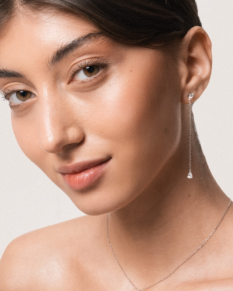 Model wearing the Talya pear diamond drop earrings in solid white gold by Anate, worn on model, portrait shot