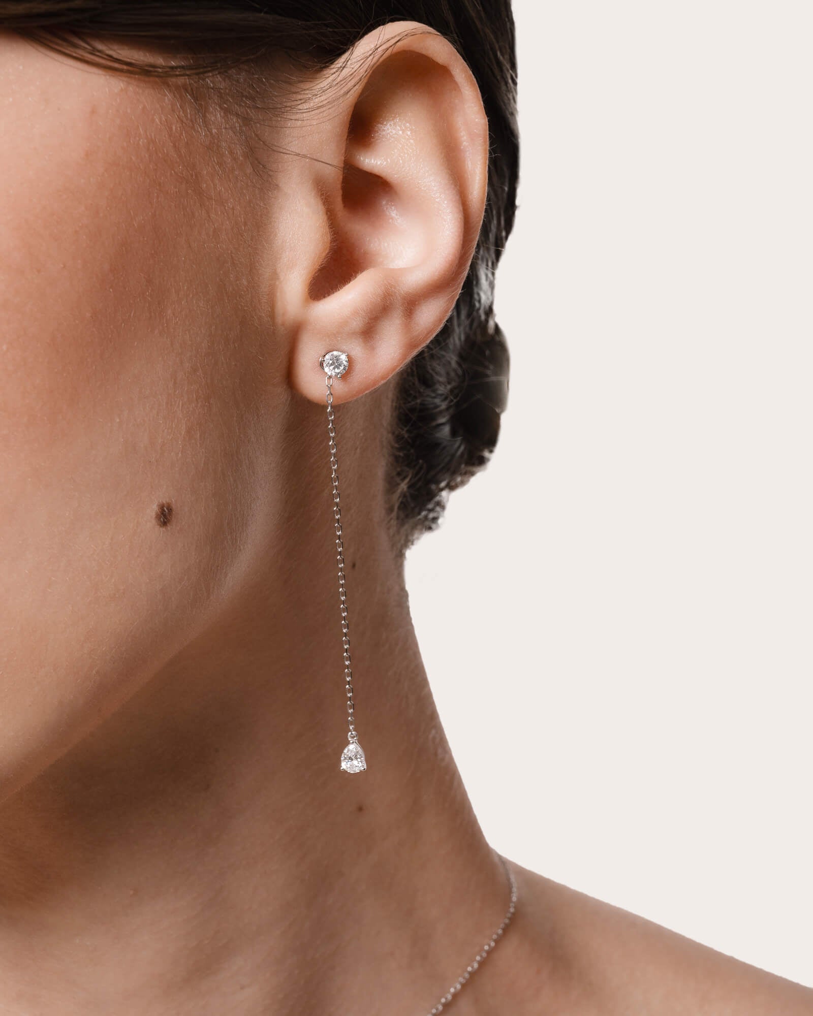 Model wearing the Talya pear diamond drop earrings in solid white gold by Anate, worn on model, side profile