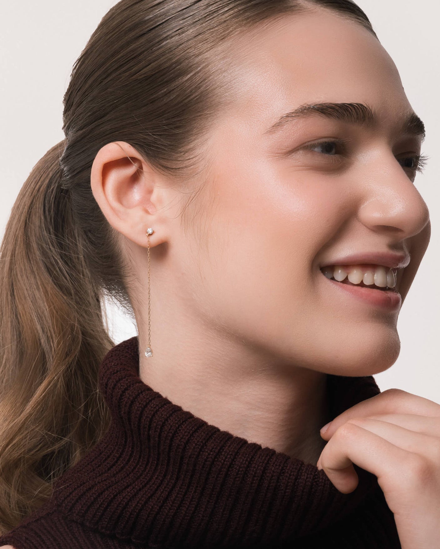 Model wearing the Talya pear diamond drop earrings in solid yellow gold by Anate, worn on ear