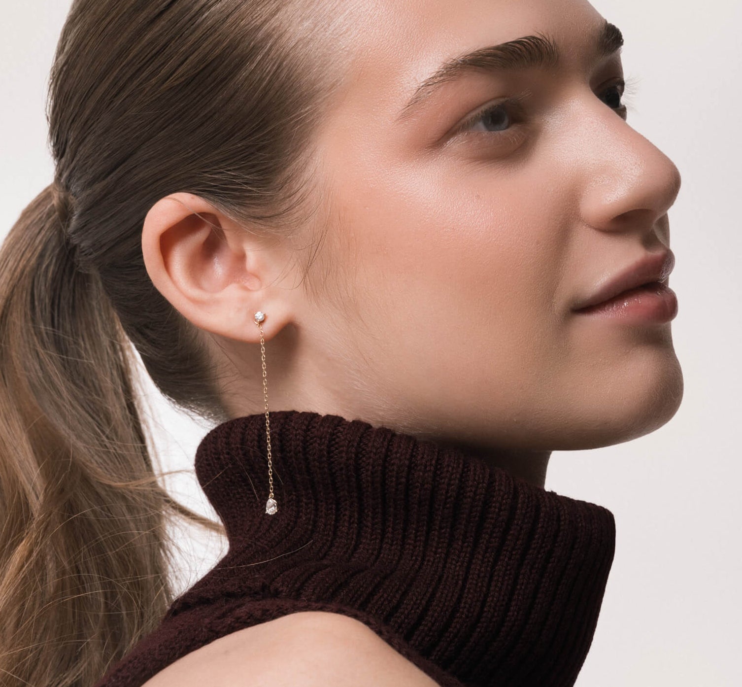 Model wearing the Talya pear diamond drop earrings in solid yellow gold by Anate, worn on ear testimonial image