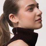 Model wearing the Talya pear diamond drop earrings in solid yellow gold by Anate, worn on ear