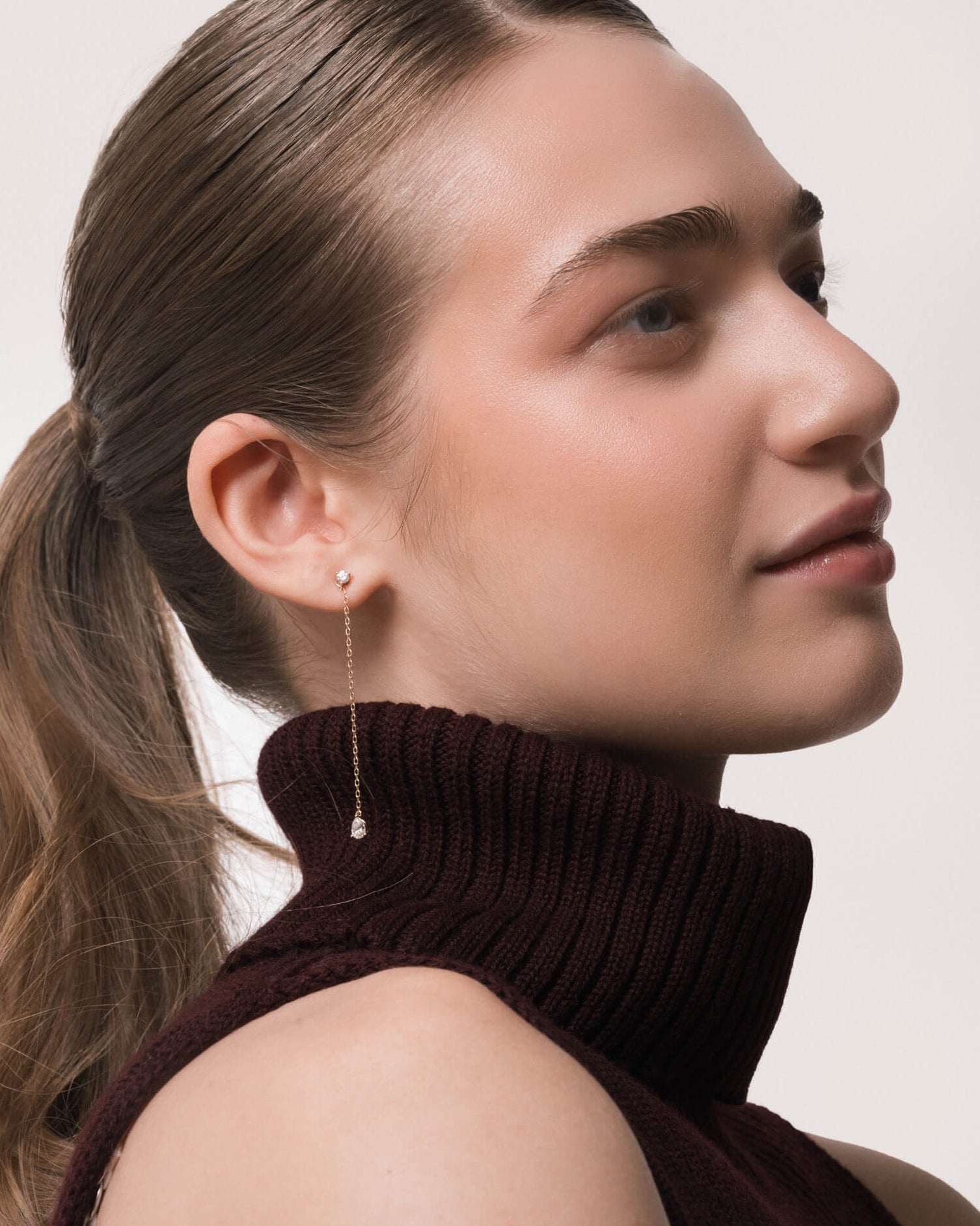 Model wearing the Talya pear diamond drop earrings in solid yellow gold by Anate, worn on ear