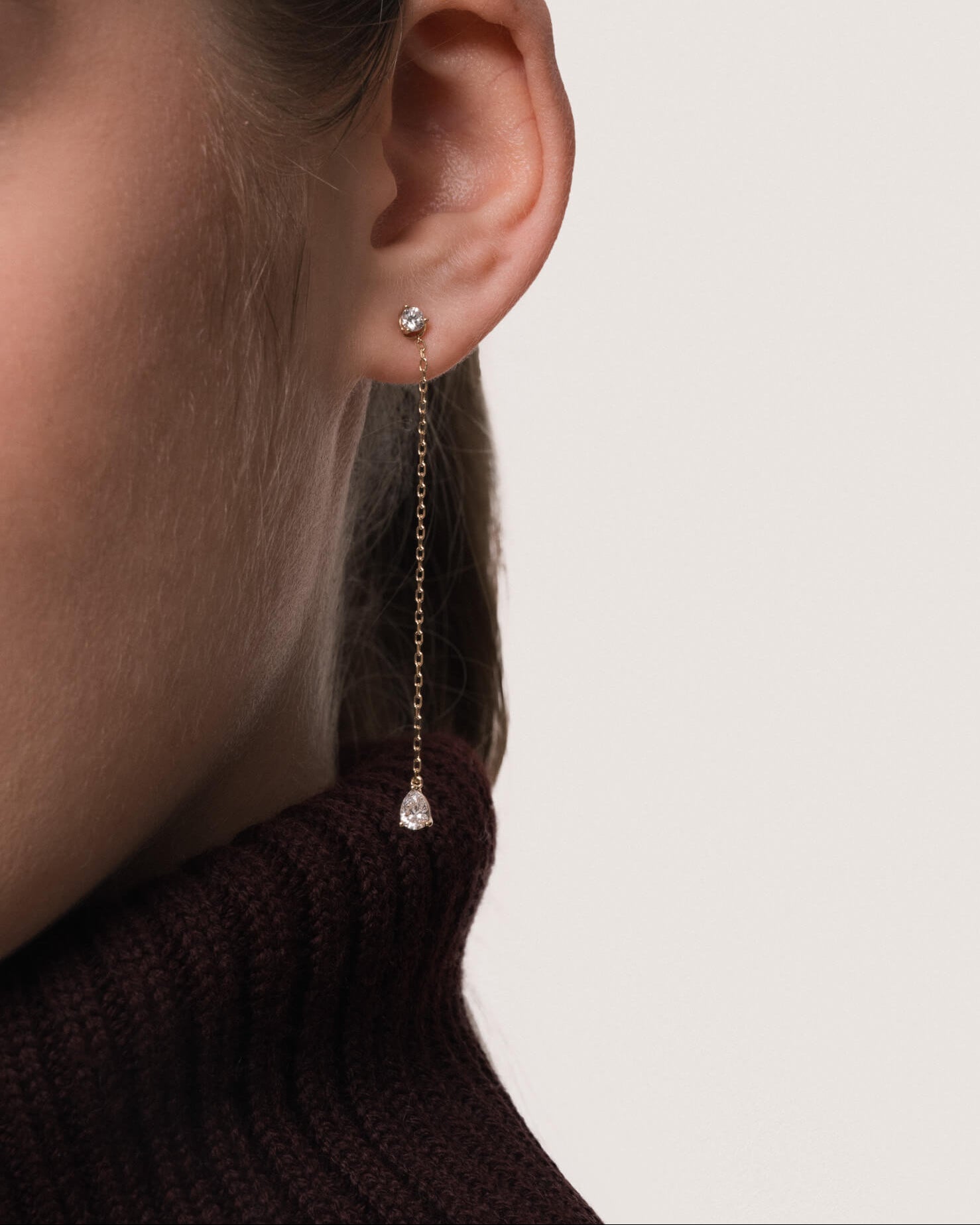 Model wearing the Talya pear diamond drop earrings in solid yellow gold by Anate, worn on ear