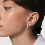 Model wearing the Nara pear diamond ear jacket earrings in solid white gold by Anate, worn on model, portrait shot variant--0.25ct
