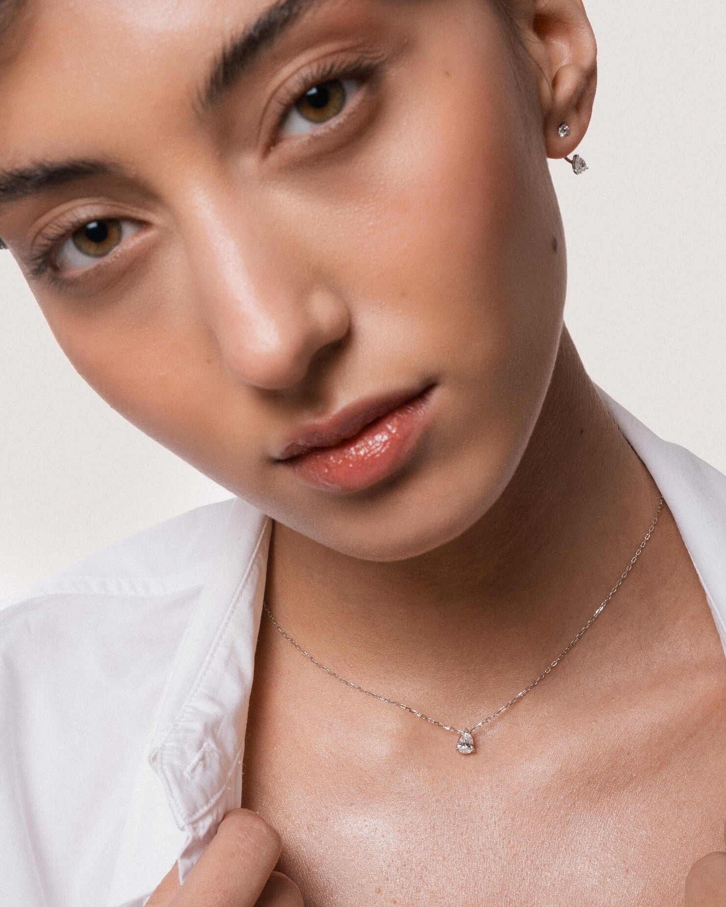 Model wearing the Liora pear diamond pendant in solid white gold by Anate, worn on model, portrait shot