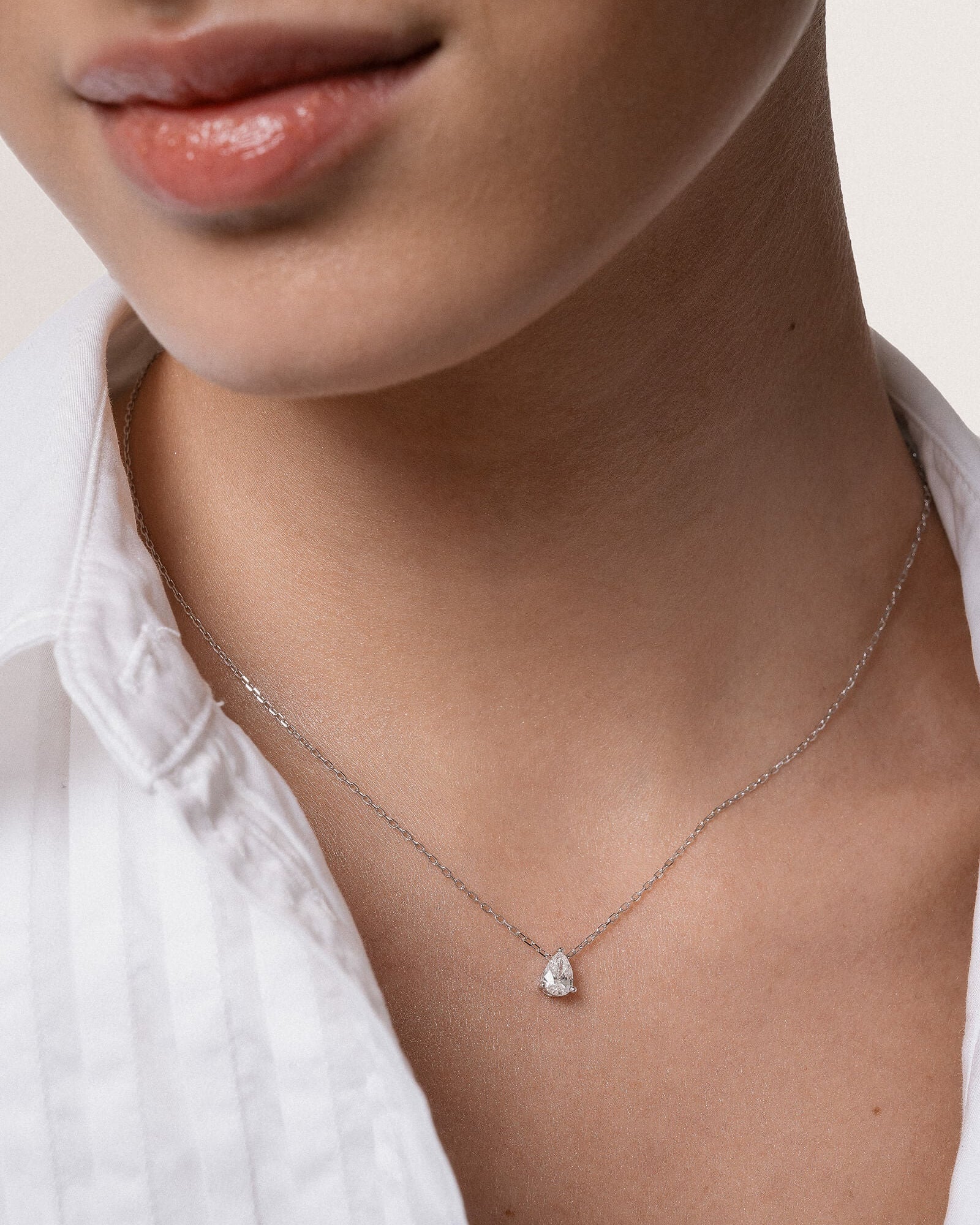 Model wearing the Liora pear diamond pendant in solid white gold by Anate, worn on neck