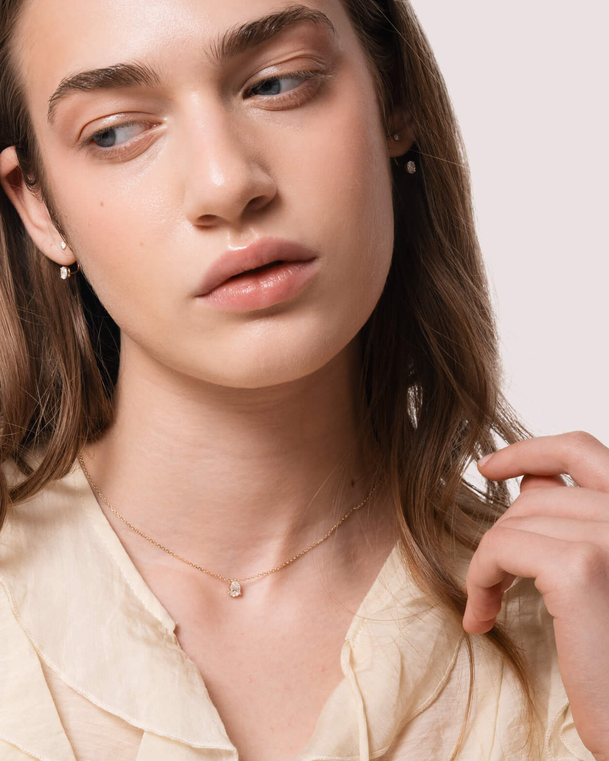 Model wearing the Liora pear diamond pendant in solid yellow gold by Anate, on-model portrait