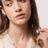 Model wearing the Liora pear diamond pendant in solid yellow gold by Anate, on-model portrait