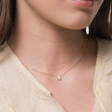 Model wearing the Liora pear diamond pendant in solid yellow gold by Anate, worn on neck