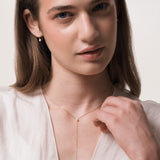 Model wearing the Kaia pear diamond tie necklace in solid yellow gold by Anate, worn on model, portrait shot
