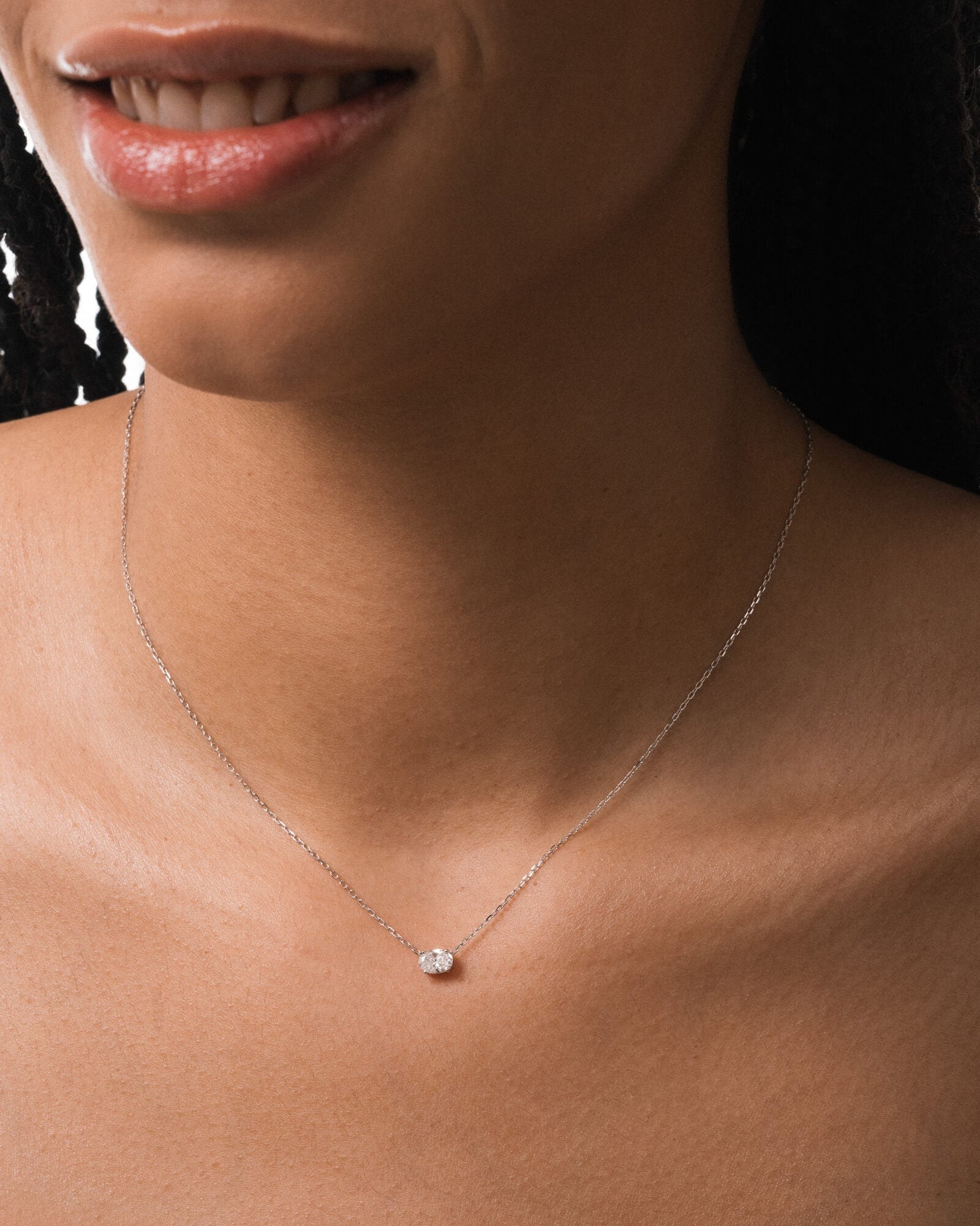 Model wearing the Elara reversible oval diamond pendant in solid white gold by Anate, worn on model, close-up