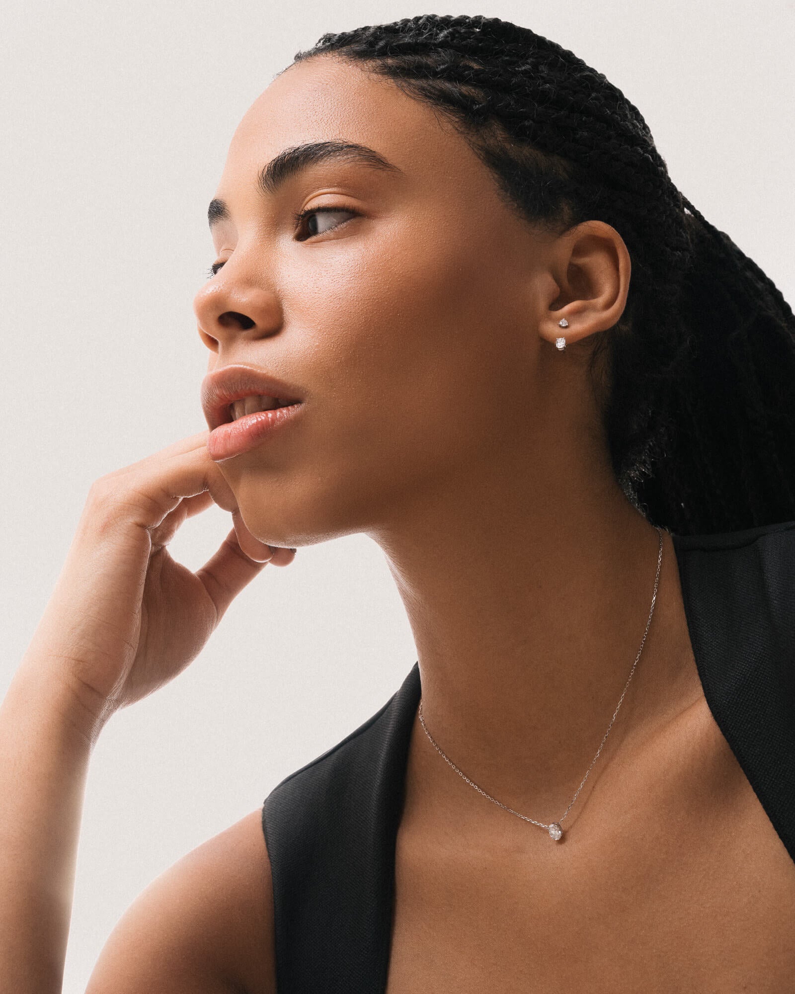 Model wearing the Elara reversible oval diamond pendant in solid white gold by Anate, worn on model, portrait shot