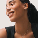 Model wearing the Elara reversible oval diamond pendant in solid white gold by Anate, worn on model, portrait shot