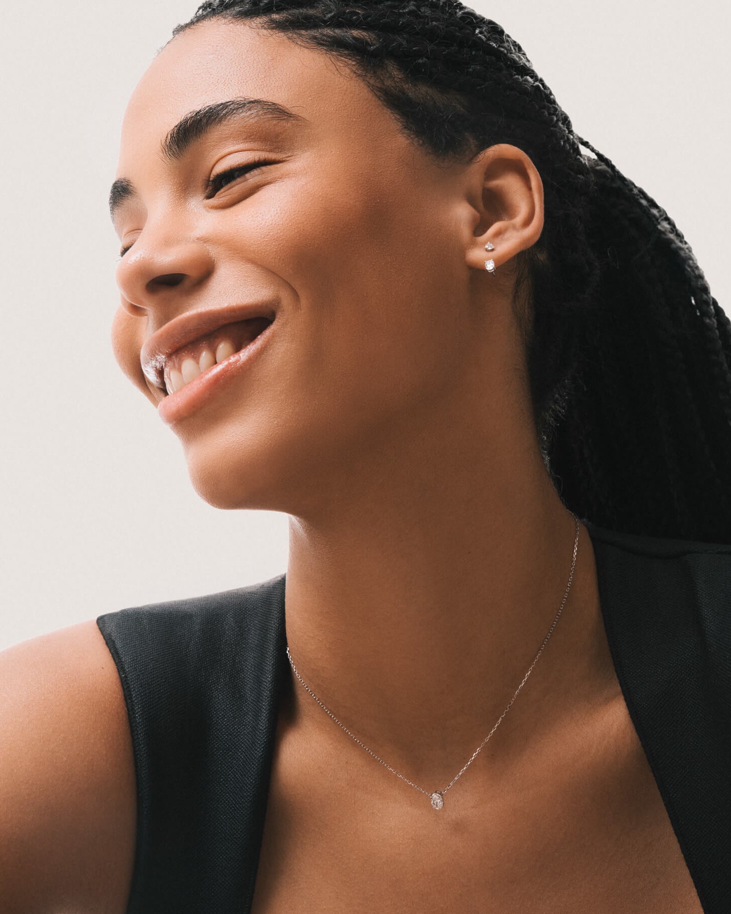 Model wearing the Elara reversible oval diamond pendant in solid white gold by Anate, worn on model, portrait shot