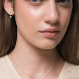 Model wearing the Elara reversible oval diamond pendant in solid yellow gold by Anate, horizontal orientation