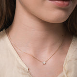 Model wearing the Elara reversible oval diamond pendant in solid yellow gold by Anate, worn on neck