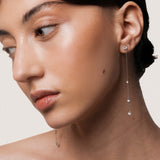 Model wearing the Aura round diamond drop earrings in solid white gold by Anate, worn on model, side profile