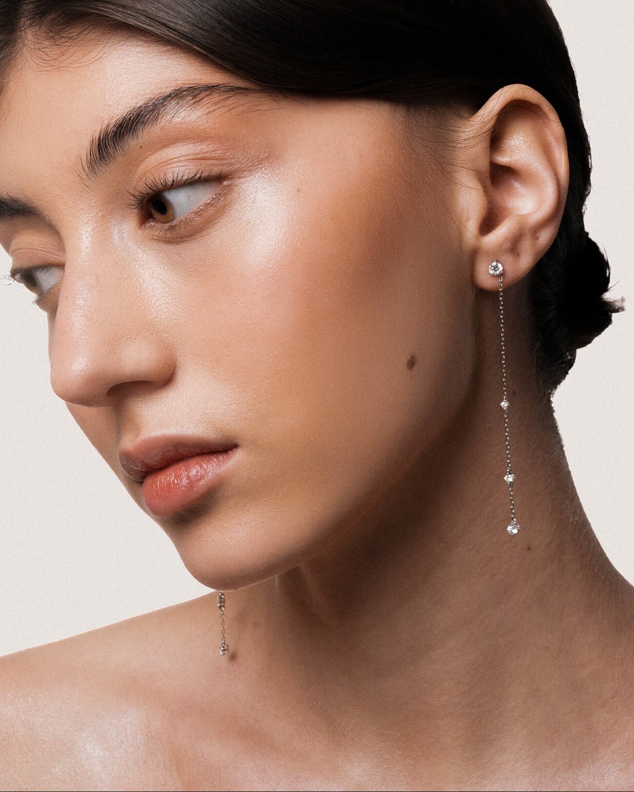 Model wearing the Aura round diamond drop earrings in solid white gold by Anate, worn on model, side profile