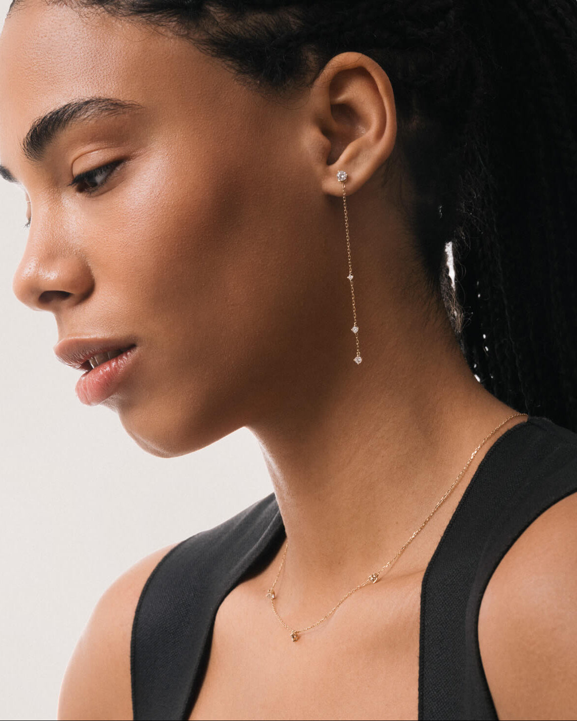 Model wearing the Aura round diamond drop earrings in solid yellow gold by Anate, worn on ear