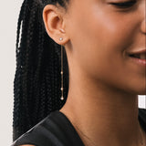 Model wearing the Aura round diamond drop earrings in solid yellow gold by Anate, worn on ear