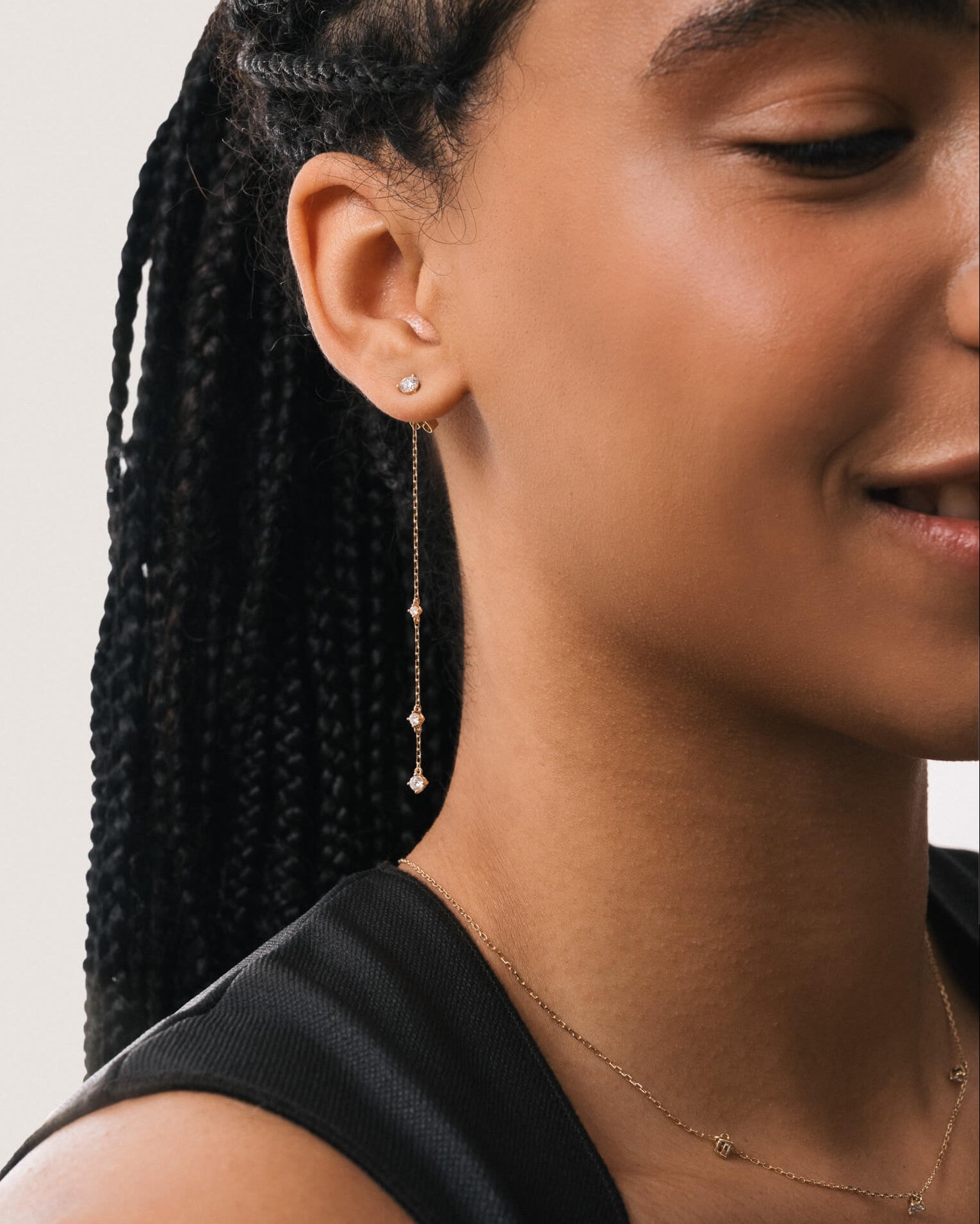 Model wearing the Aura round diamond drop earrings in solid yellow gold by Anate, worn on ear