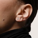 Model wearing the Astra round diamond stud earrings in solid white gold by Anate, worn on ear variant--0.25ct