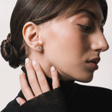Model wearing the Astra round diamond stud earrings in solid white gold by Anate, worn on ear variant--0.50ct