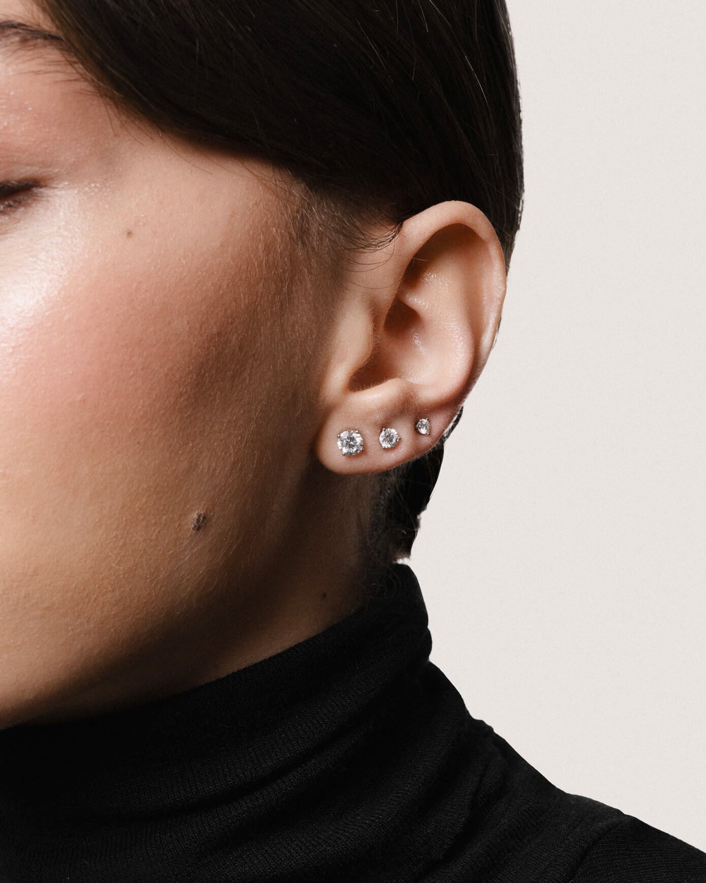 Model wearing the Astra round diamond stud earrings in solid white gold by Anate, worn on ear