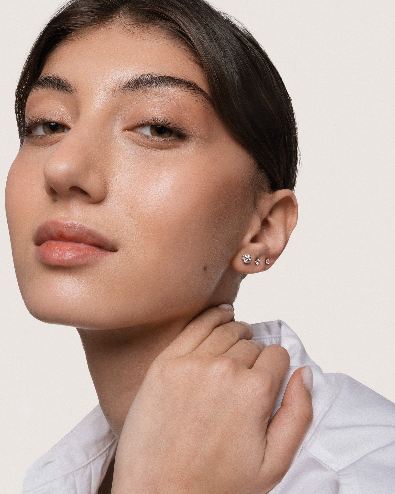 Model wearing the Astra round diamond stud earrings in solid yellow gold by Anate, worn on model, portrait shot