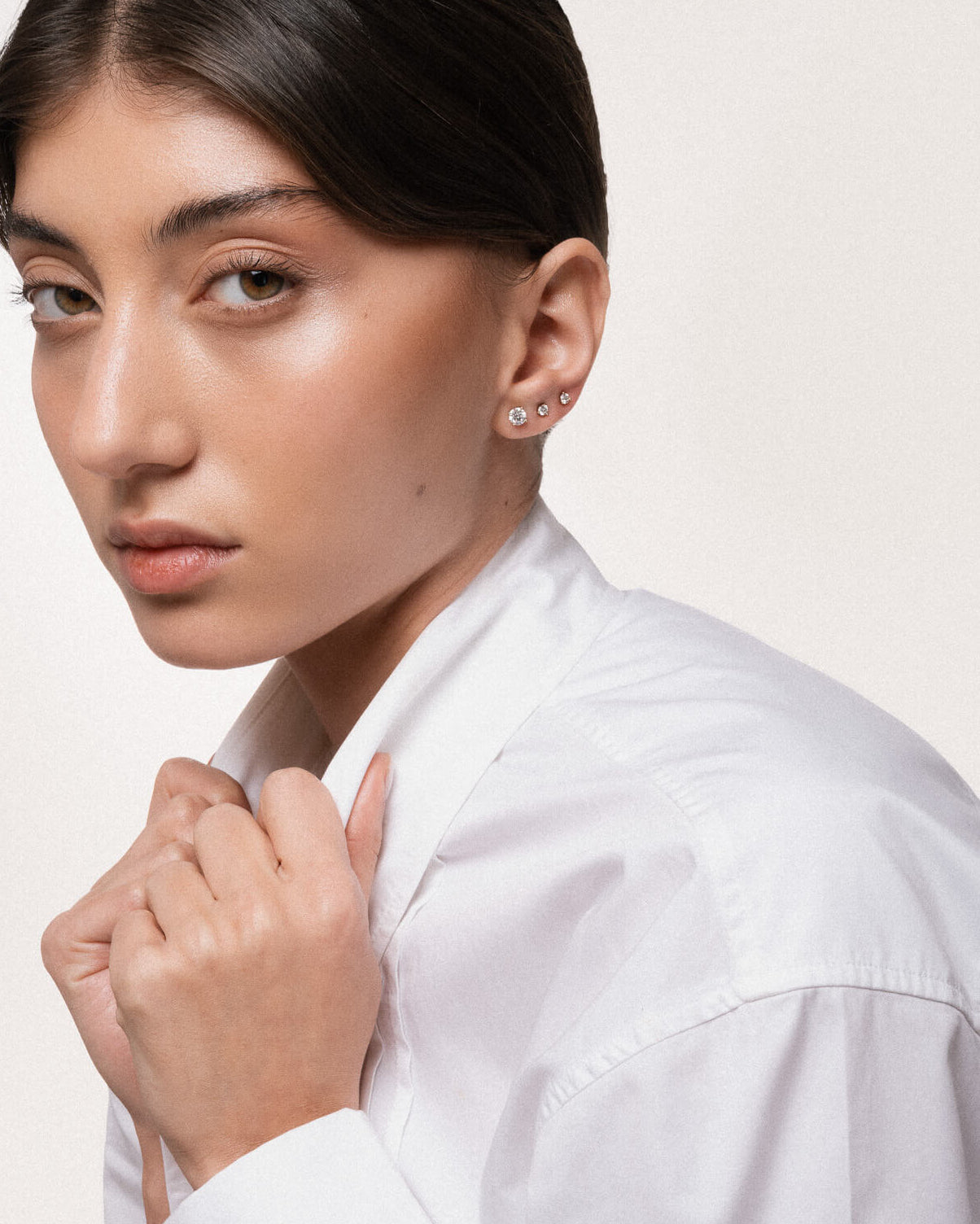 Model wearing the Astra round diamond stud earrings in solid yellow gold by Anate, worn on model, side profile