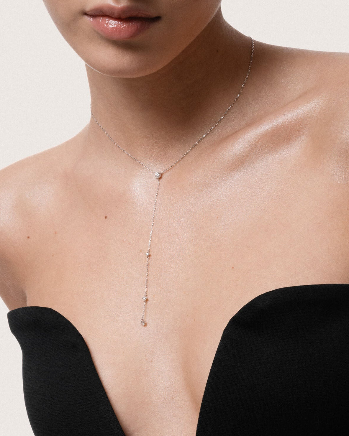 Model wearing the Luna round diamond tie necklace in solid white gold by Anate, worn on neck
