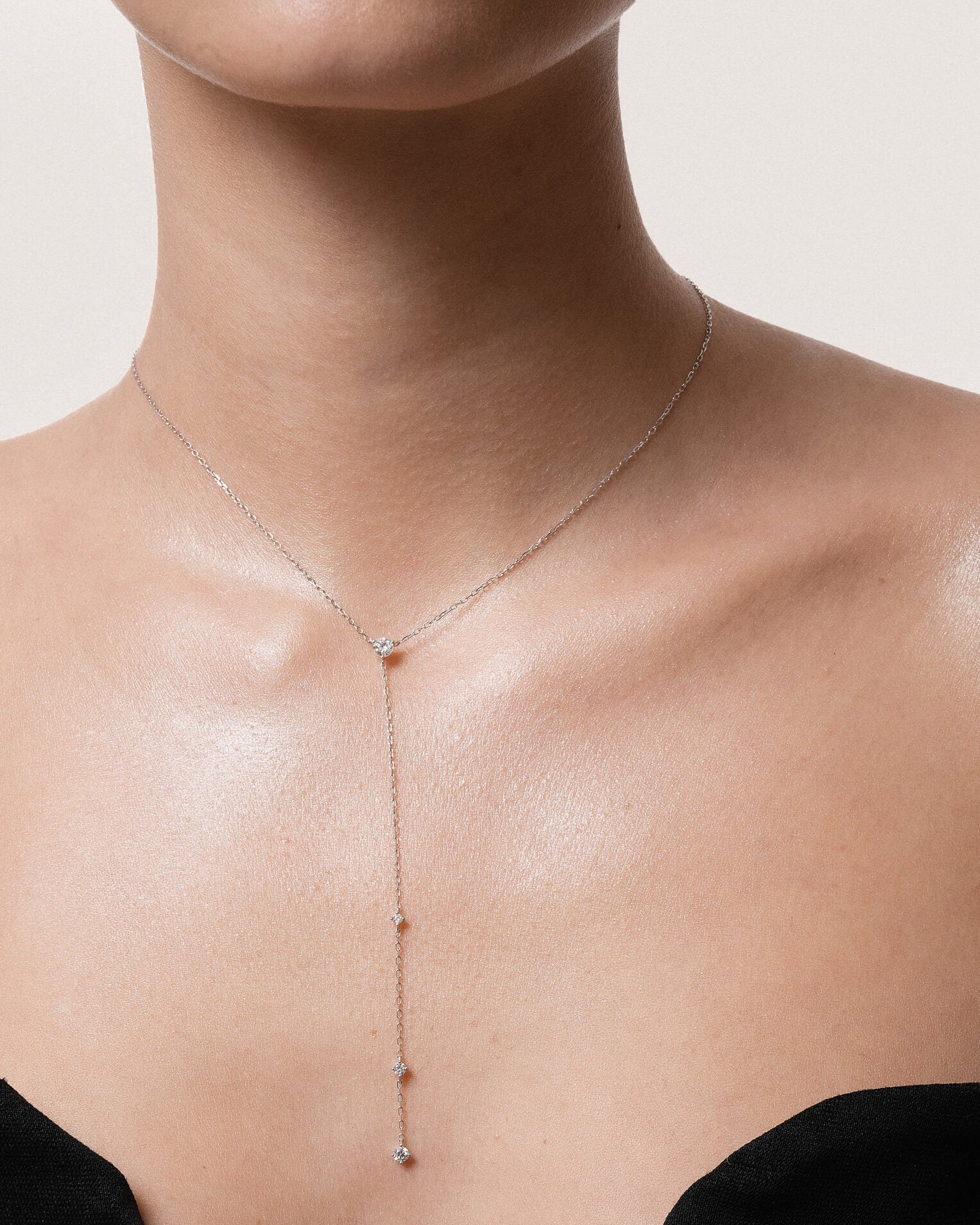 Model wearing the Luna round diamond tie necklace in solid white gold by Anate, worn on neck