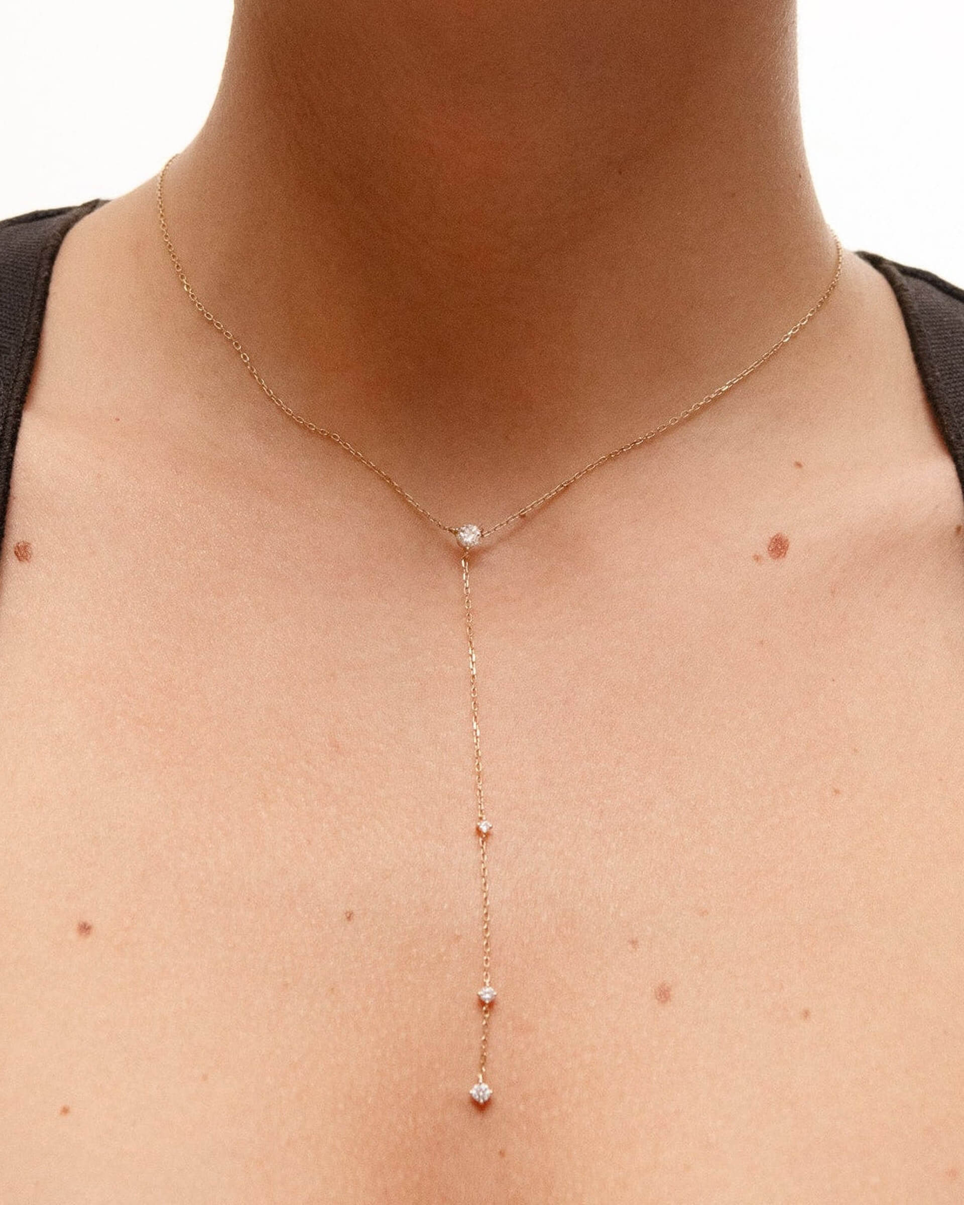 Model wearing the Luna round diamond tie necklace in solid yellow gold by Anaté, worn on neck