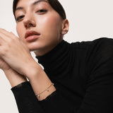 Model wearing the Tria three diamond bracelet in solid yellow gold by Anate, worn on model, portrait shot