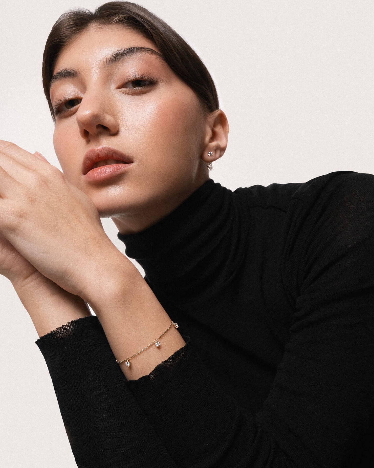 Model wearing the Tria three diamond bracelet in solid yellow gold by Anate, worn on model, portrait shot