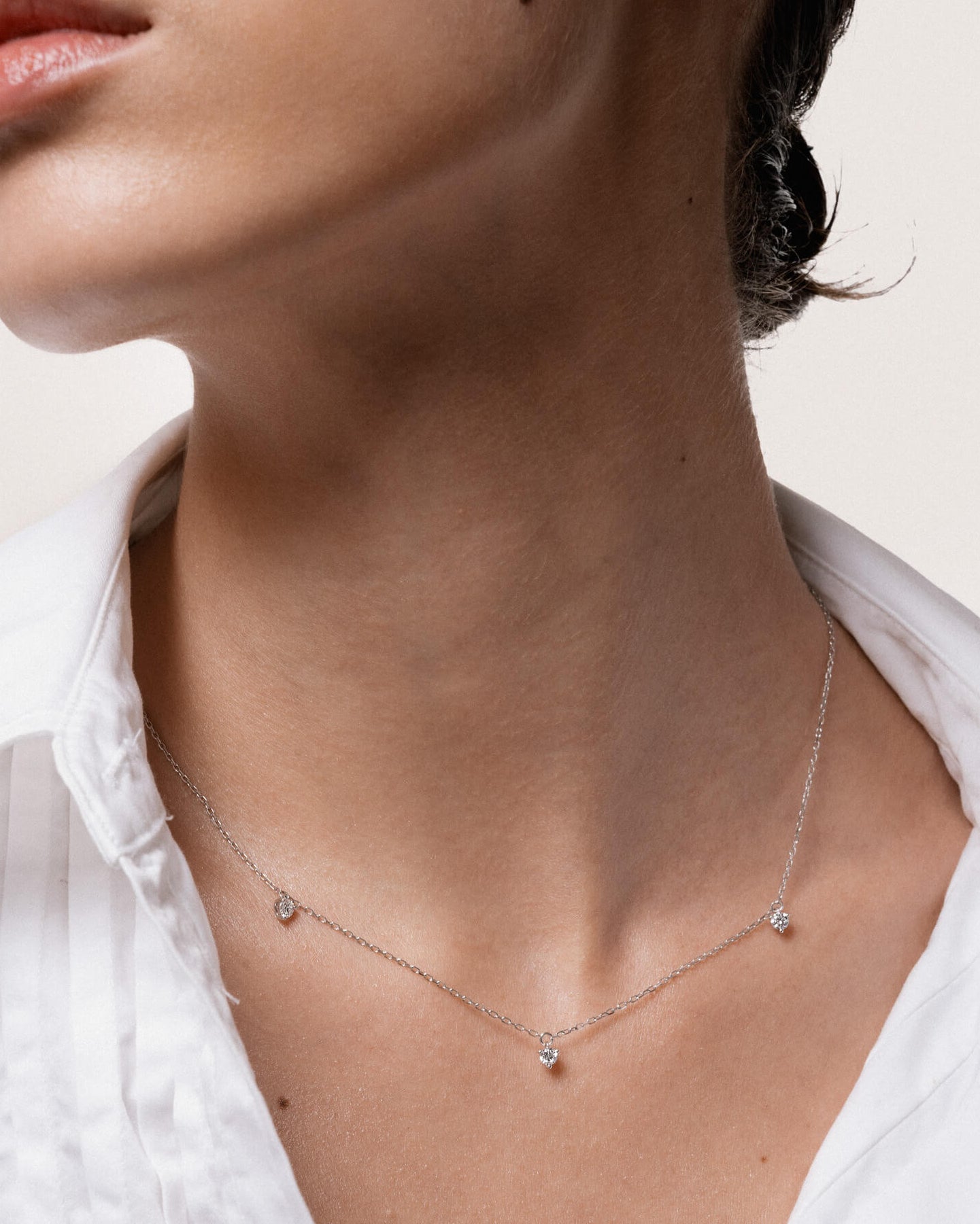 Model wearing the Elio three diamond necklace in solid white gold by Anate, worn on neck