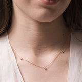 Model wearing the Elio three diamond necklace in solid yellow gold by Anate, worn on neck