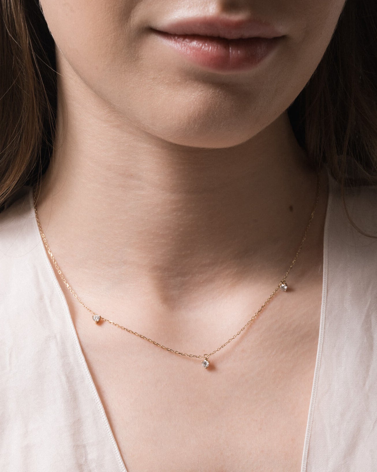 Model wearing the Elio three diamond necklace in solid yellow gold by Anate, worn on neck