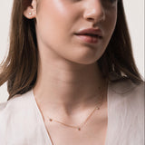 Model wearing the Elio three diamond necklace in solid yellow gold by Anate, worn on neck
